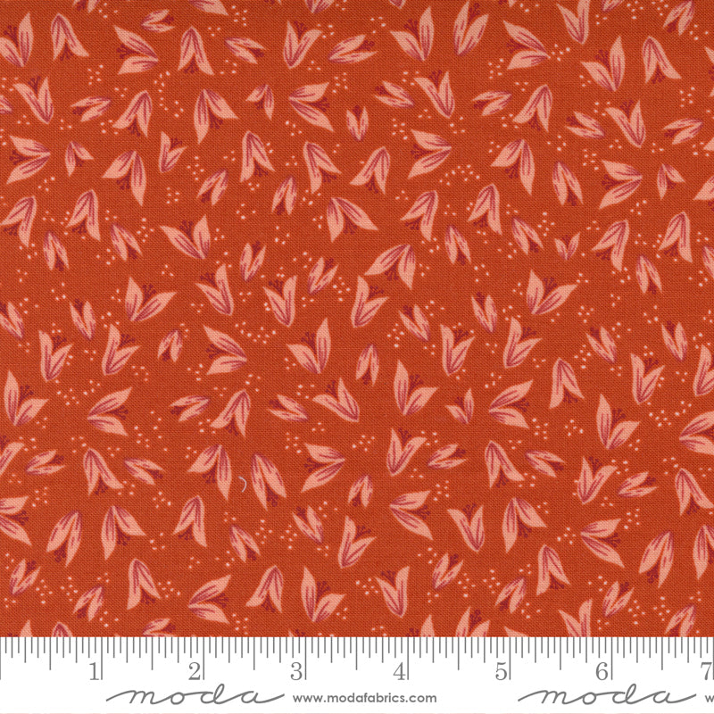 A print fabric of peach flower buds on red